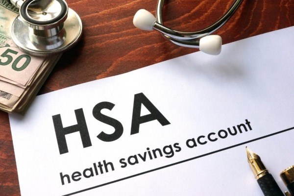 Close-up of HSA document next to money and stethoscope