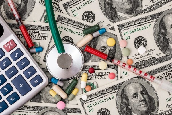Close-up of drugs and stethoscope on top of money