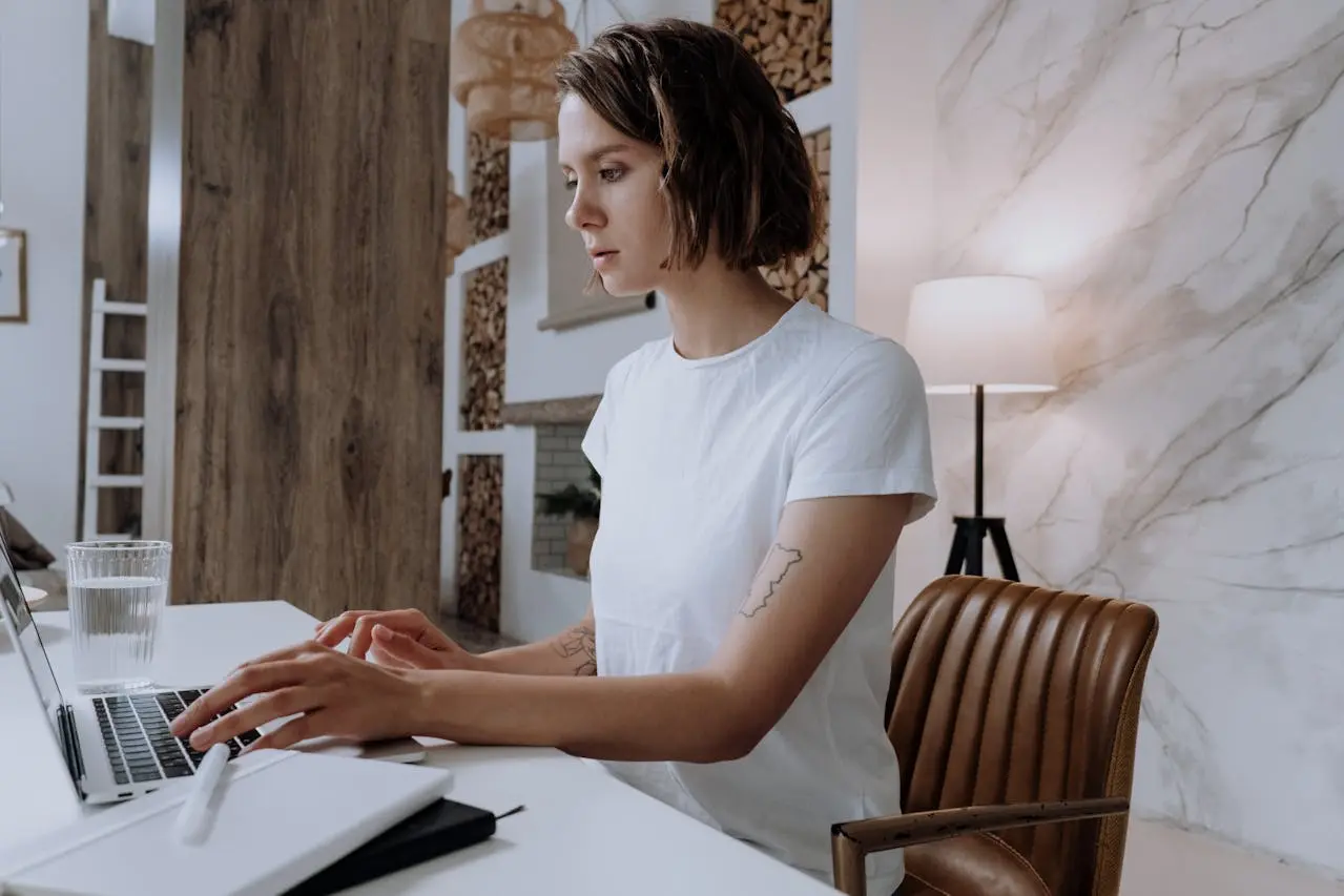 Woman working on a laptop with a diary open while researching are health insurance premiums tax deductible self-employed