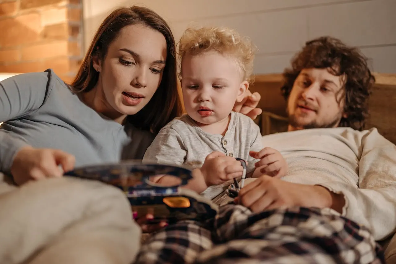 Parents reading with a toddler at home, representing family health insurance in texas for young families.
