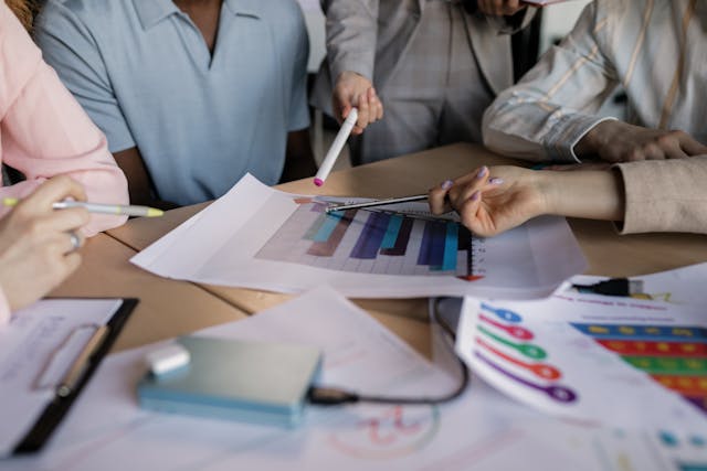 Small business team reviewing charts and reports to compare health insurance cost for small business plan options