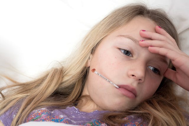 Sick child with thermometer showing why Aetna short term health insurance matters for families