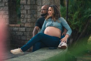 Short term health insurance pregnancy - couple expecting baby reviewing coverage options outdoors