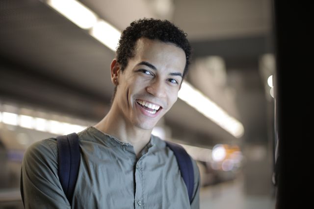 Happy young man smiling after learning about the turning 26 health insurance grace period options available to him