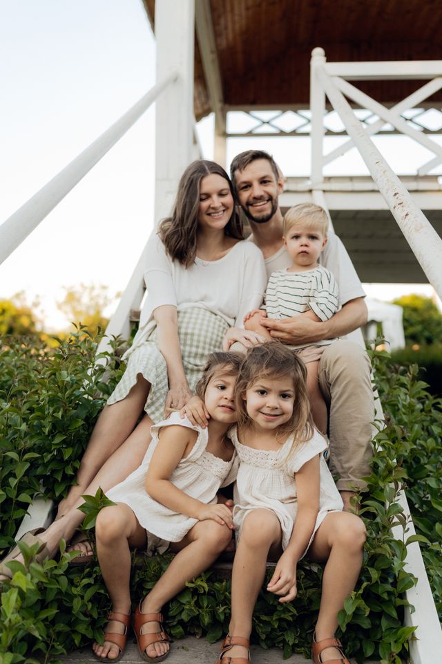 Smiling young family with three children sitting together outdoors, representing coverage options for Short-Term Health Insurance in Texas