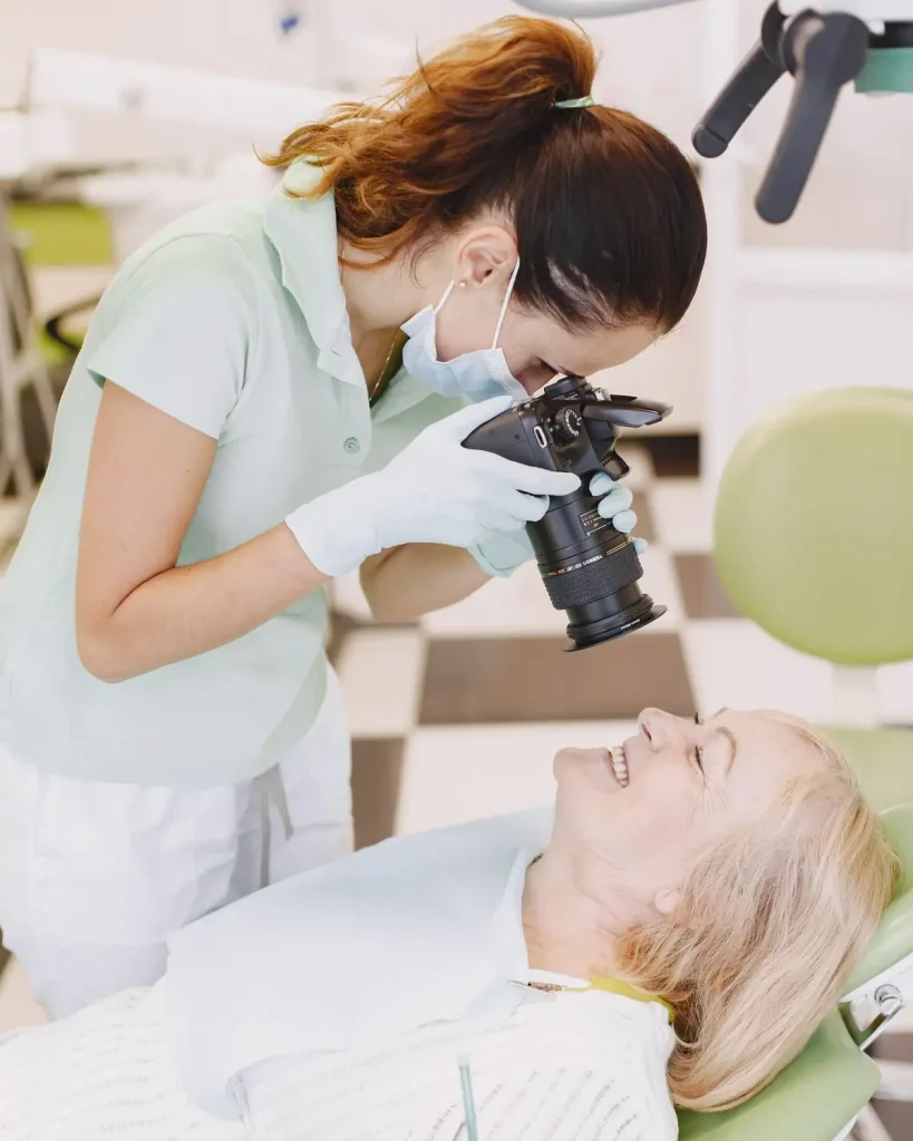 Older woman smiling at a dental check-up, the age group most in need of the best dental insurance in Texas once Medicare begins