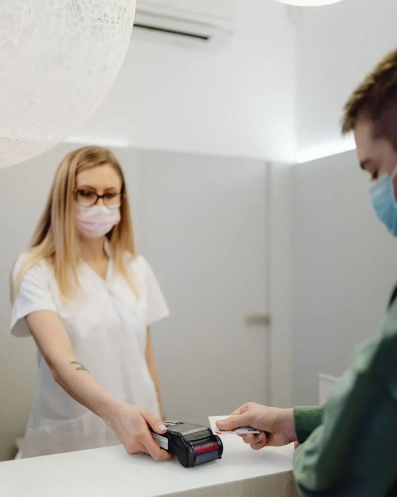 Patient settling a bill at a clinic counter with the cash benefit from fixed indemnity health insurance