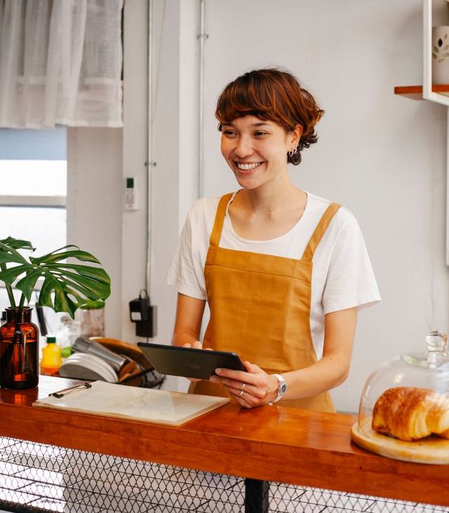Texas small business owner checking employee health insurance plans on tablet