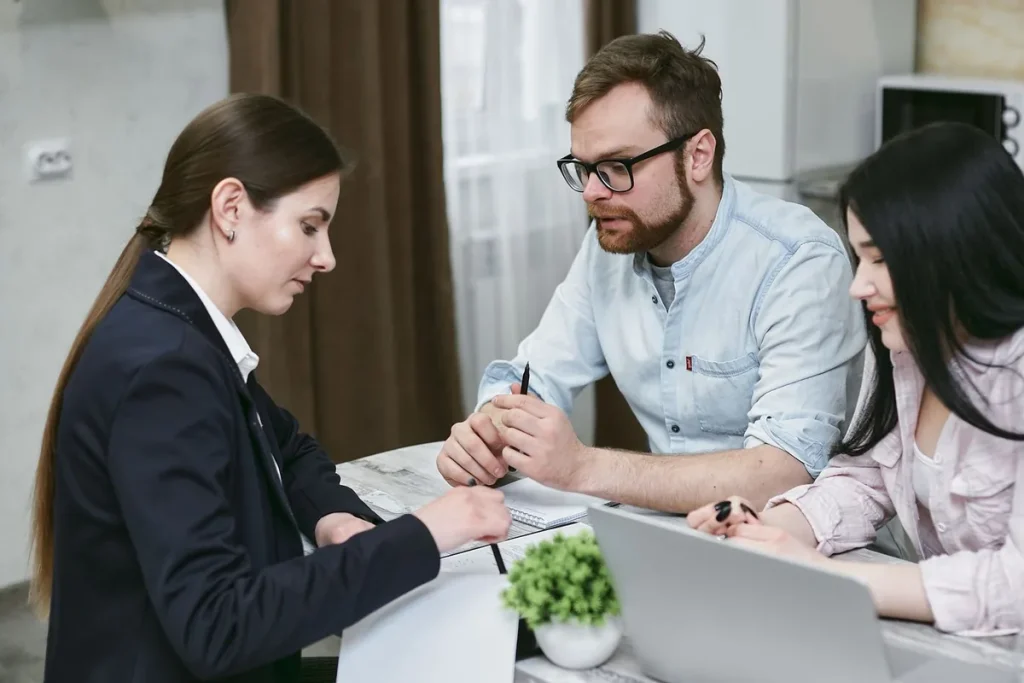 Licensed broker comparing Texas health insurance plans with a couple on a laptop
