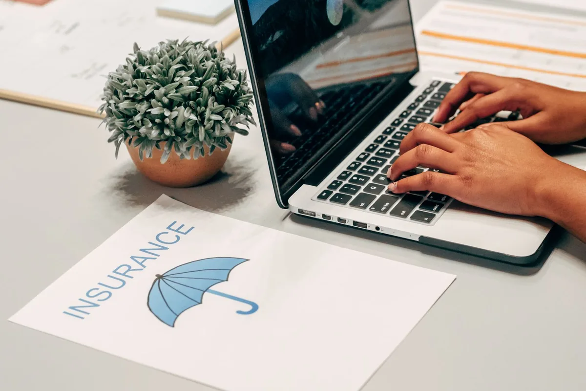 Comparing Texas individual health insurance quotes on a laptop beside an insurance policy form