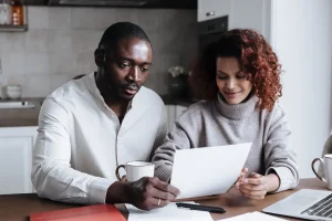 Couple at a kitchen table comparing plan documents while working out when is open enrollment for health insurance 2026