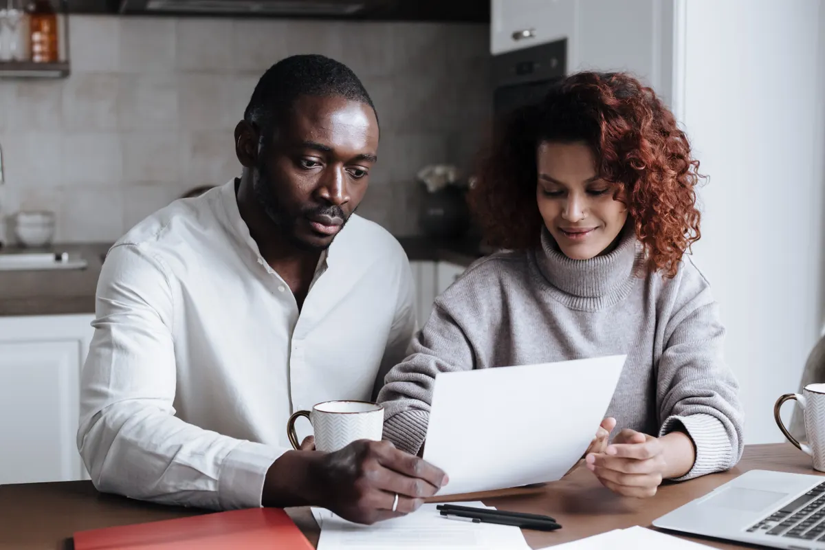 Couple at a kitchen table comparing plan documents while working out when is open enrollment for health insurance 2026