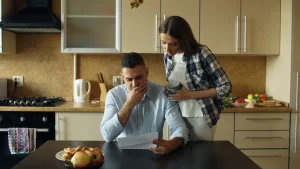 Couple reading a COBRA renewal letter in their kitchen as COBRA open enrollment approaches