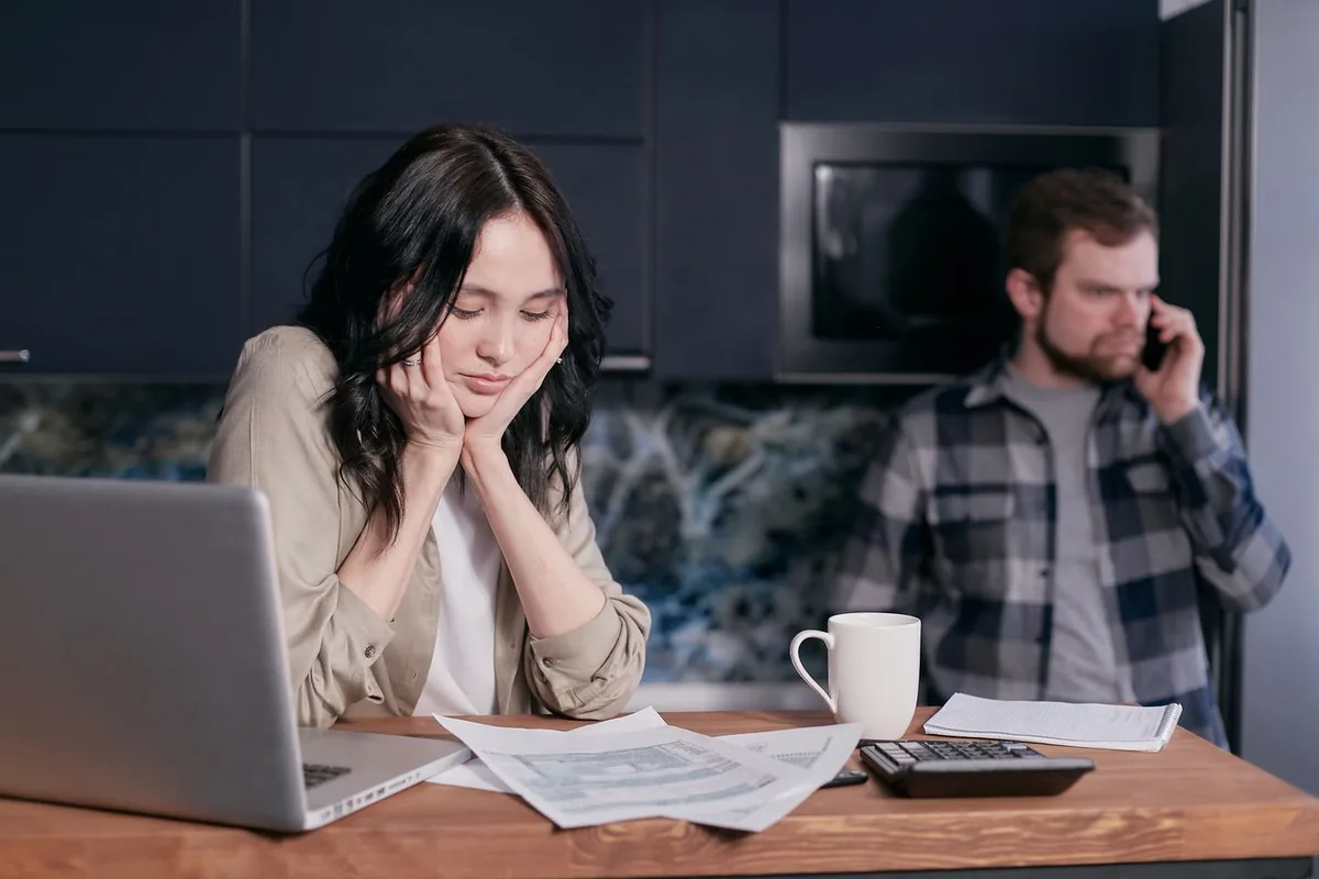 Couple at a kitchen table with bills deciding what to do after they missed open enrollment for health insurance