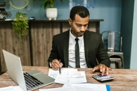 can i change my health insurance plan after enrollment: a Texas policyholder comparing plan paperwork with a calculator and laptop