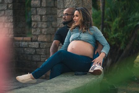 Short term health insurance pregnancy - couple expecting baby reviewing coverage options outdoors