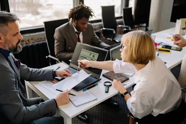 Business team reviewing health insurance plans for small business with broker at office meeting